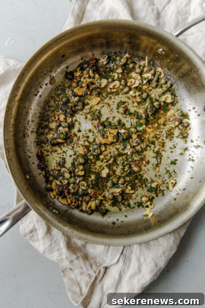 Brown Butter Almond Trout 4 Close-up of butter browning in a skillet with sliced almonds, a key step in making Trout Almondine sauce.