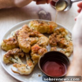 Hot Honey Cauliflower Steaks 6 Fried Cauliflower Steaks with Honey and Hot Sauce served on a white plate