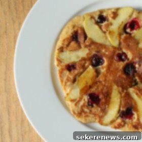 Warm Spiced Apple Cranberry Pancakes 6 Cinnamon Apple Cranberry Pancakes plated with maple syrup