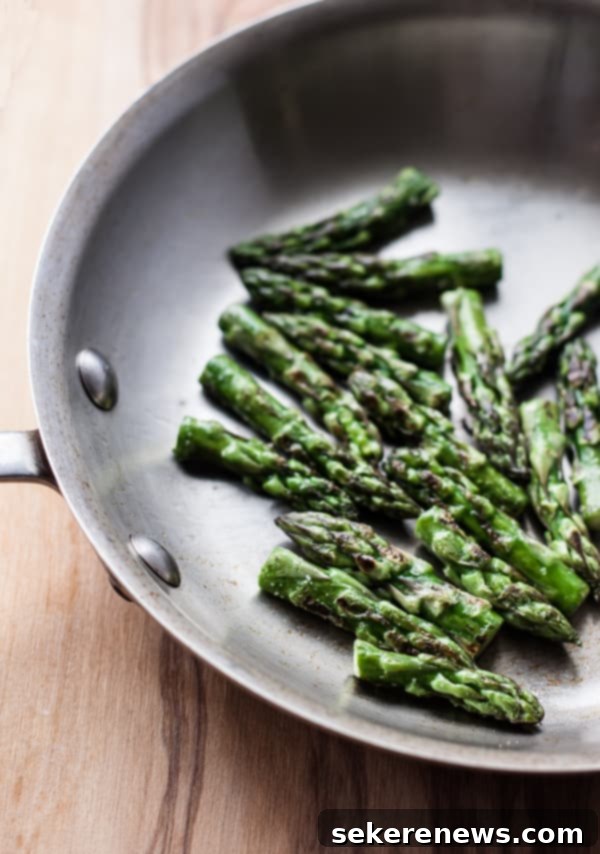 Perfect Asparagus Every Time 5 Sautéed Asparagus Tips in a pan with garlic and cherry tomatoes