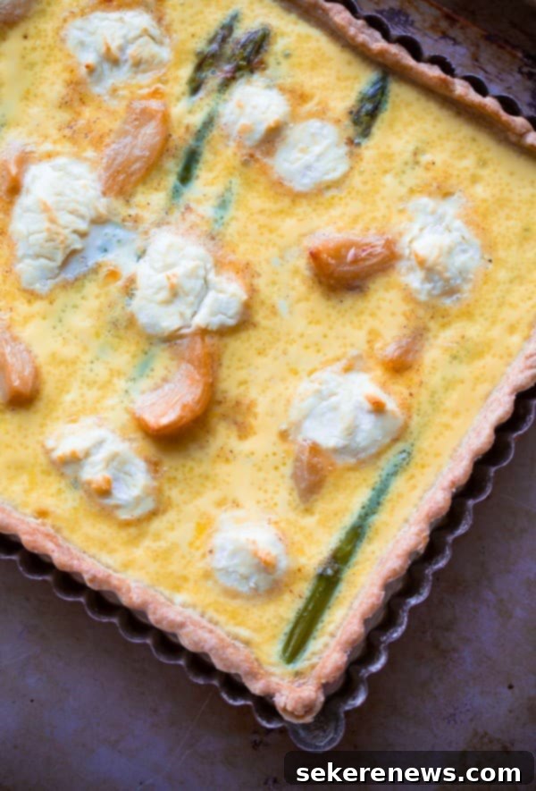 Perfect Asparagus Every Time 10 A slice of Asparagus Goat Cheese Quiche on a wooden board