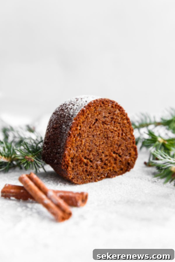 Holiday Gingerbread Bundt with Velvety Eggnog Cream 2 Close-up of a slice of moist Gingerbread Bundt Cake on a white plate, showcasing its beautiful texture and golden-brown crust, ready to be enjoyed.