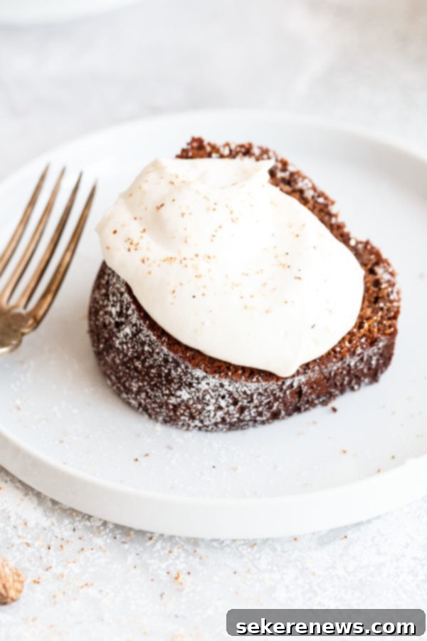 Holiday Gingerbread Bundt with Velvety Eggnog Cream 6 Another appealing perspective of the Gingerbread Bundt Cake with a dollop of eggnog whipped cream, highlighting its inviting texture and festive appeal.