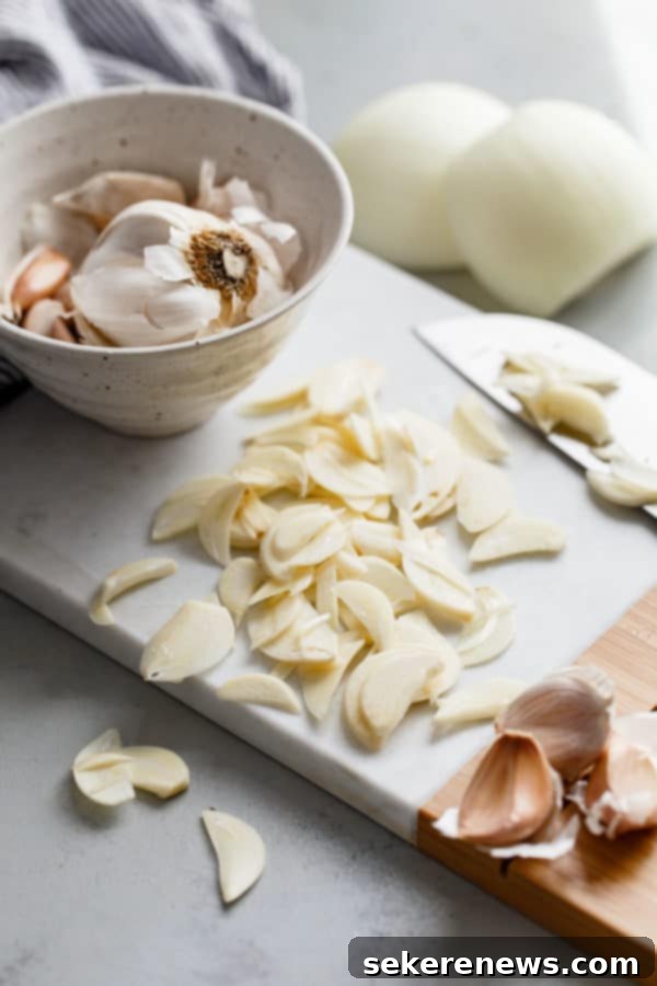 How to Make Crispy Garlic Chips - An easy, no-fuss tutorial on how to make crispy garlic chips at home, and ways to incorporate them into your cooking repertoire. Thinly Sliced Garlic Cloves on Cutting Board