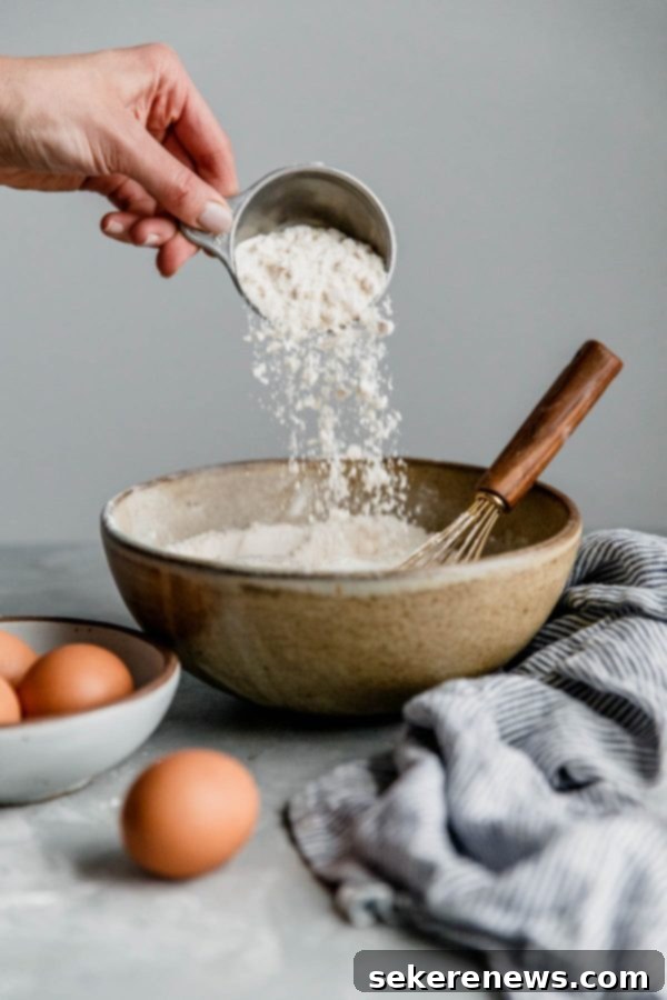 Preparing Carrot Cake Batter with Quality Bob's Red Mill Flour Adding Bob's Red Mill All-Purpose Flour to a Mixing Bowl for Carrot Cake