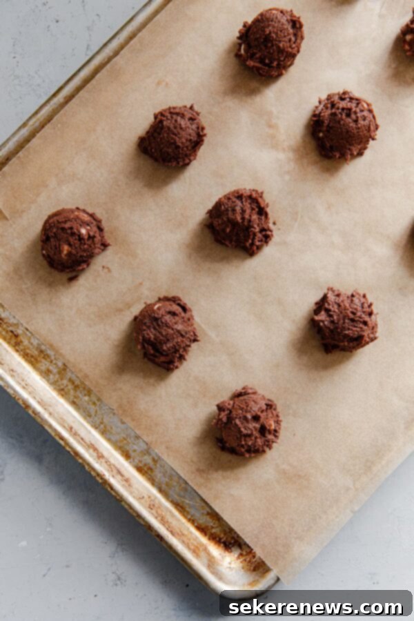 Triple Chocolate Dream Cookies 5 Portioned triple chocolate cookie dough balls on a baking sheet, ready for the oven