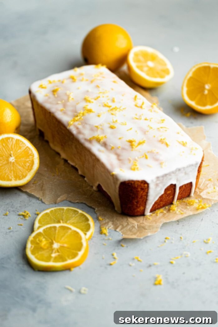 Zesty Lemon Pound Cake 2 A beautifully sliced lemon loaf cake with a generous layer of tart lemon glaze and fresh lemon zest, ready to be served on a white plate, highlighting its moist texture and vibrant color.