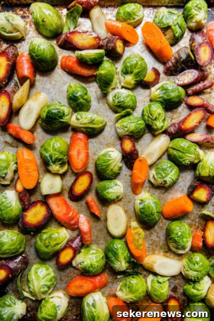 Hearty Autumn Farro Salad 3 Sheet pan filled with roasted Brussels sprouts and colorful tri-color carrots, ready to be added to the farro salad.