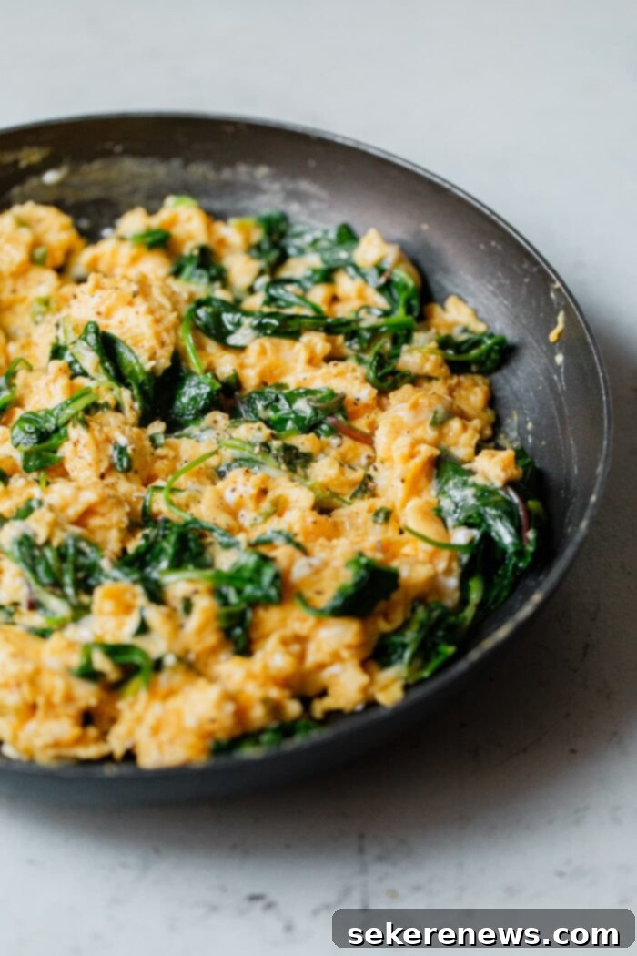 Fluffy Cheesy Scramble with Fresh Greens 2 Cheesy Scrambled Eggs with Greens in Skillet