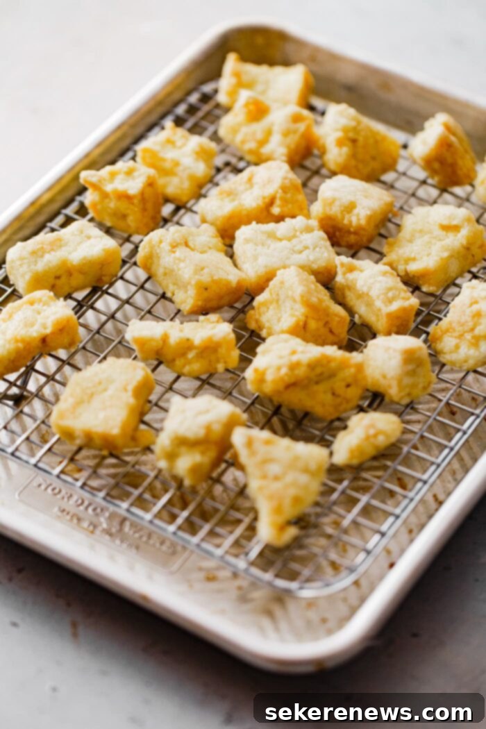 Spicy Chili Peanut Tofu Crunch 5 Crispy Baked Tofu pieces on a baking sheet