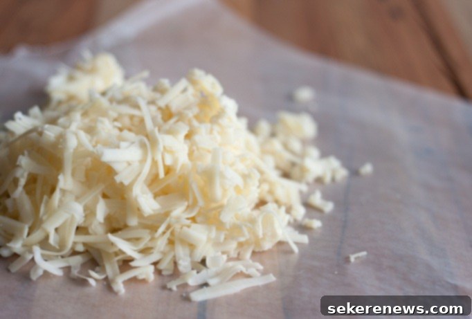 Close-up of freshly grated white cheddar cheese, an essential ingredient for cheesy Polenta Al Forno